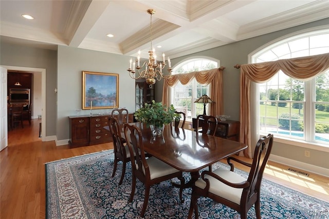 dining room featuring crown molding, coffered ceiling, a chandelier, and beam ceiling