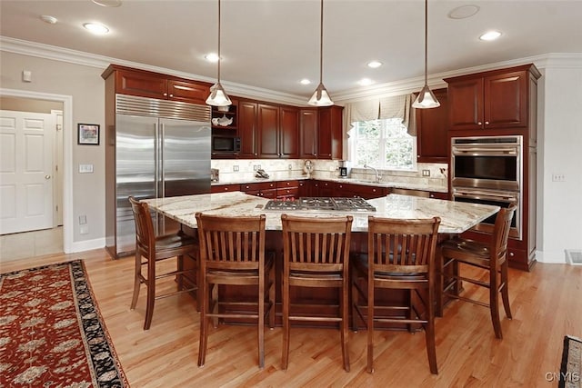 kitchen with tasteful backsplash, stainless steel appliances, decorative light fixtures, and light stone counters