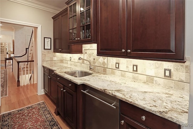 kitchen with sink, light stone counters, light wood-type flooring, ornamental molding, and backsplash