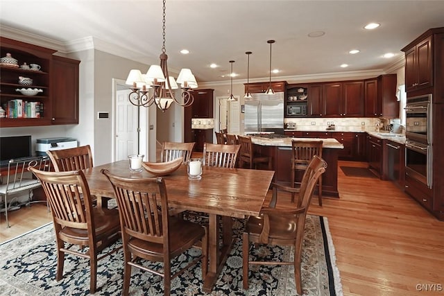 dining space featuring ornamental molding, light hardwood / wood-style floors, and a chandelier