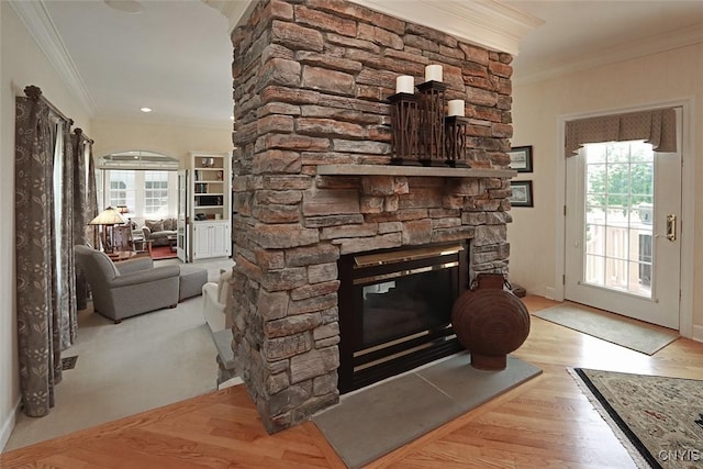 living room featuring crown molding, a fireplace, and light hardwood / wood-style floors