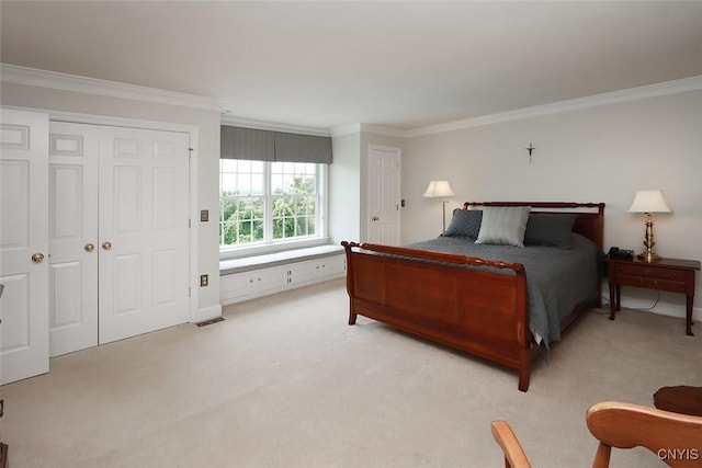 carpeted bedroom with ornamental molding and a closet