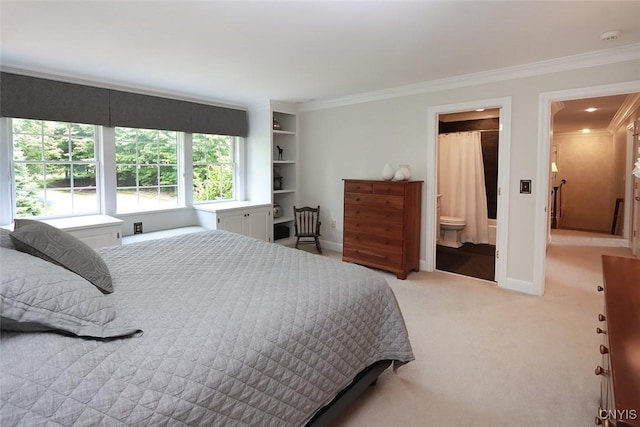 bedroom with crown molding, ensuite bath, and light colored carpet