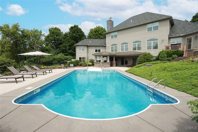 view of swimming pool with a patio and a lawn