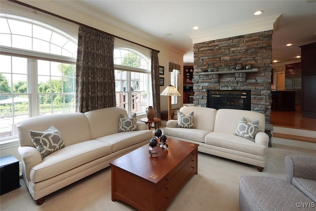 living room with ornamental molding, plenty of natural light, light colored carpet, and a stone fireplace