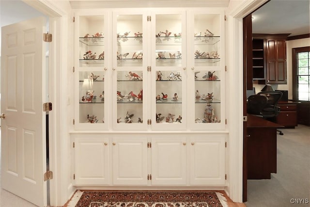 interior space with white cabinetry, light carpet, and built in features