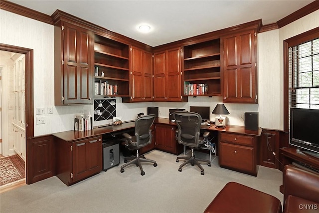 office area featuring crown molding, built in desk, and light carpet