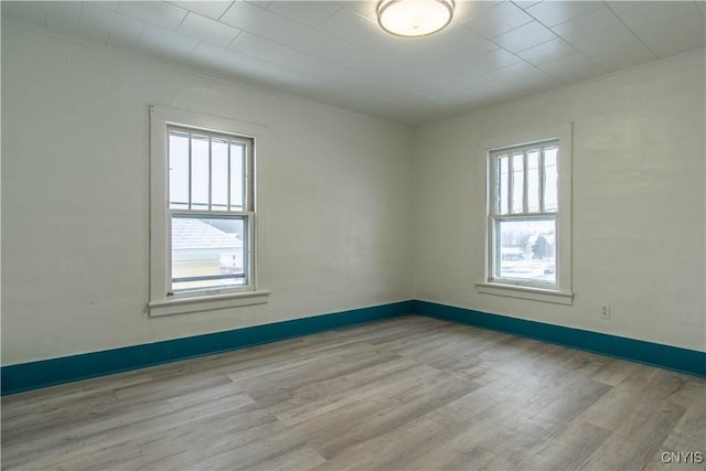 empty room featuring crown molding and light hardwood / wood-style floors