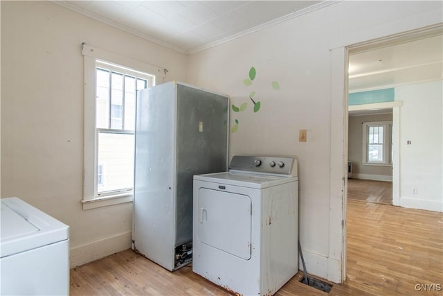 washroom with ornamental molding, washer / dryer, and light hardwood / wood-style floors