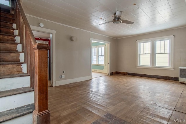 unfurnished living room featuring ornamental molding, a healthy amount of sunlight, ceiling fan, and light wood-type flooring