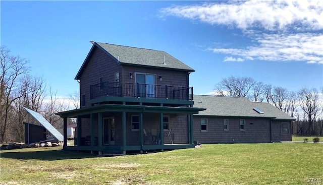 back of property featuring a lawn, covered porch, a balcony, and a shingled roof