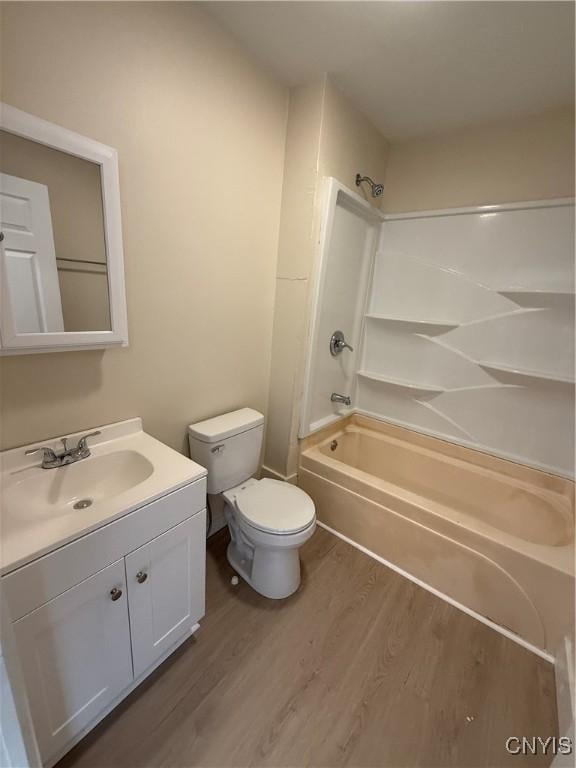 full bathroom with wood-type flooring, toilet, shower / bathing tub combination, and vanity