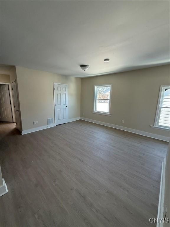 unfurnished room with a healthy amount of sunlight and dark hardwood / wood-style flooring