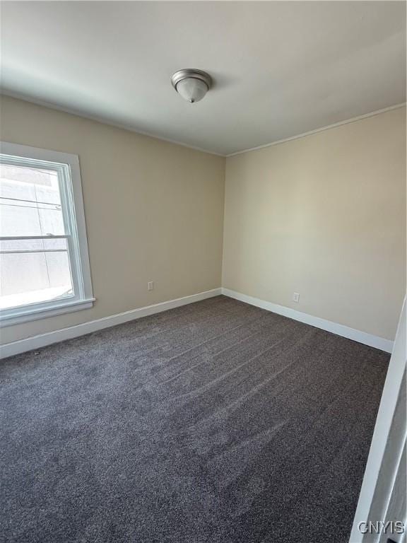 spare room featuring dark colored carpet