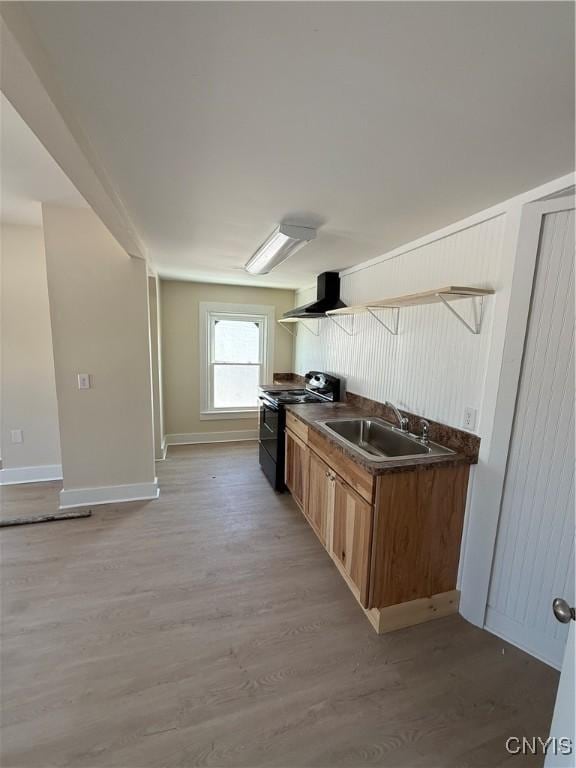 kitchen featuring range with electric cooktop, sink, light wood-type flooring, and wall chimney exhaust hood