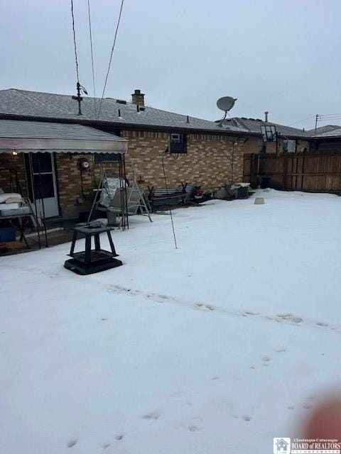 view of snow covered back of property