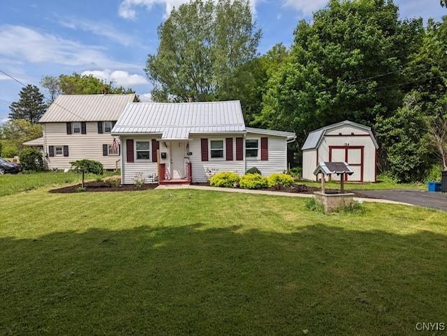 view of front of property featuring a shed and a front lawn