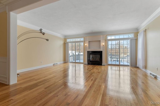 unfurnished living room featuring light hardwood / wood-style flooring and ornamental molding