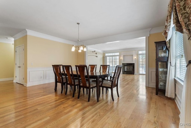 dining space featuring crown molding, a chandelier, and light hardwood / wood-style floors