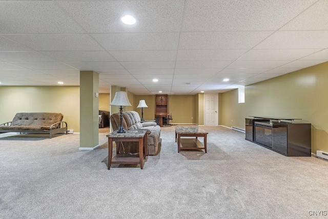 carpeted living room featuring a baseboard radiator and a paneled ceiling