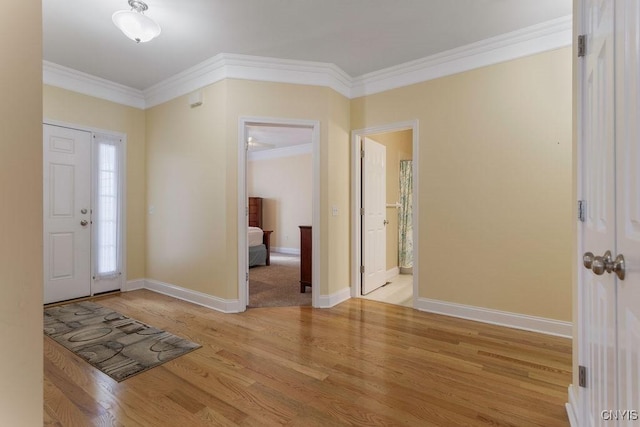 entryway with ornamental molding and light wood-type flooring