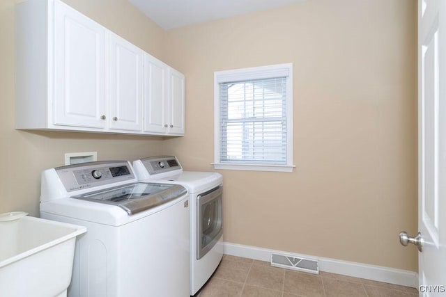 laundry area featuring cabinets, washing machine and clothes dryer, sink, and light tile patterned floors