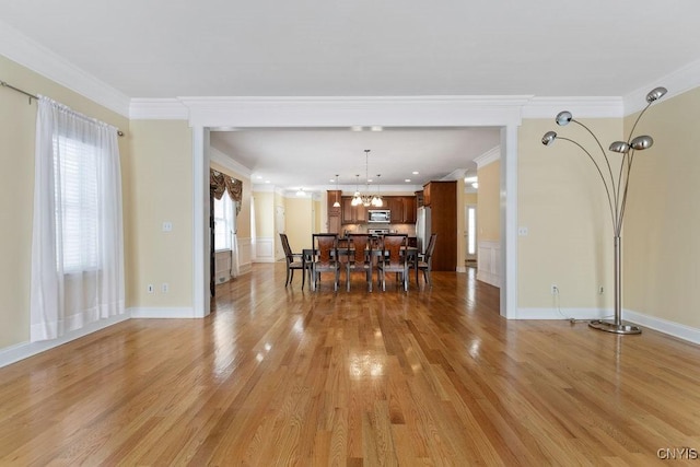 dining area featuring ornamental molding and light hardwood / wood-style floors