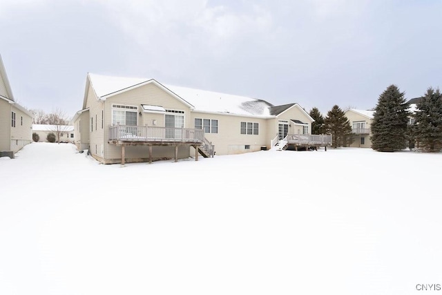 snow covered rear of property featuring a wooden deck