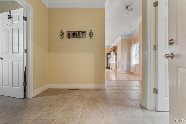 corridor featuring ornamental molding and light tile patterned flooring