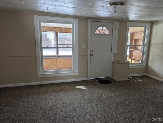 entryway with crown molding and carpet floors