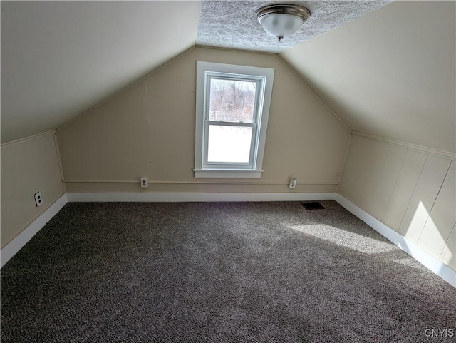 bonus room with vaulted ceiling, carpet, and a textured ceiling