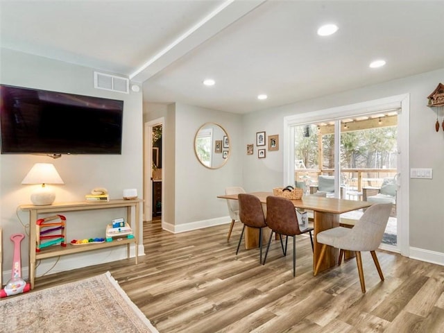 dining space featuring wood-type flooring and beamed ceiling