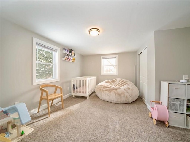 bedroom with a nursery area and carpet flooring