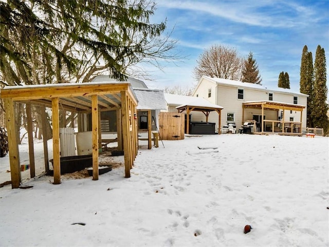 snow covered property featuring a hot tub