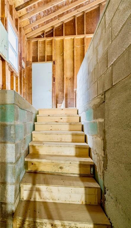 staircase featuring lofted ceiling