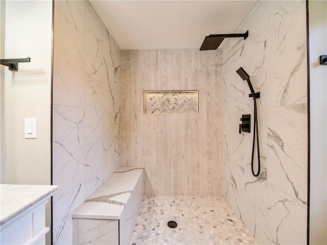 bathroom featuring tiled shower and vanity