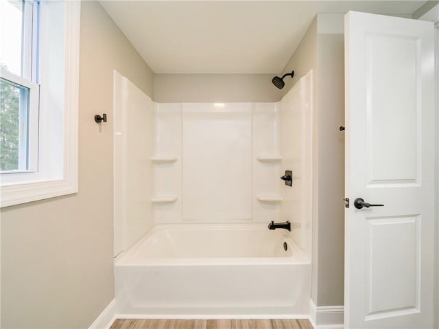 bathroom featuring wood-type flooring and washtub / shower combination