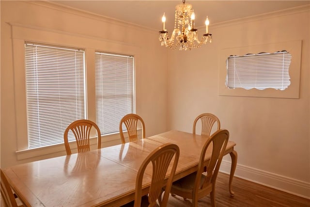 dining room with hardwood / wood-style flooring, crown molding, and a chandelier