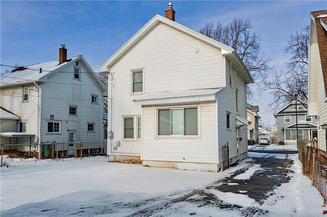 snow covered back of property with central AC