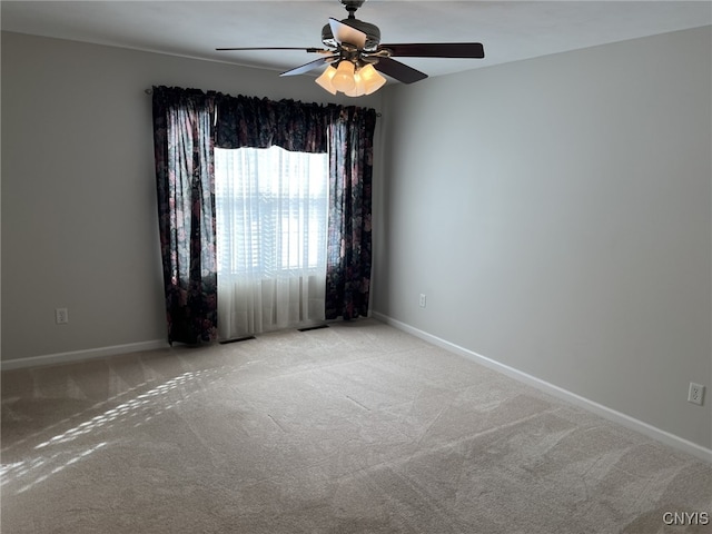 carpeted spare room featuring ceiling fan