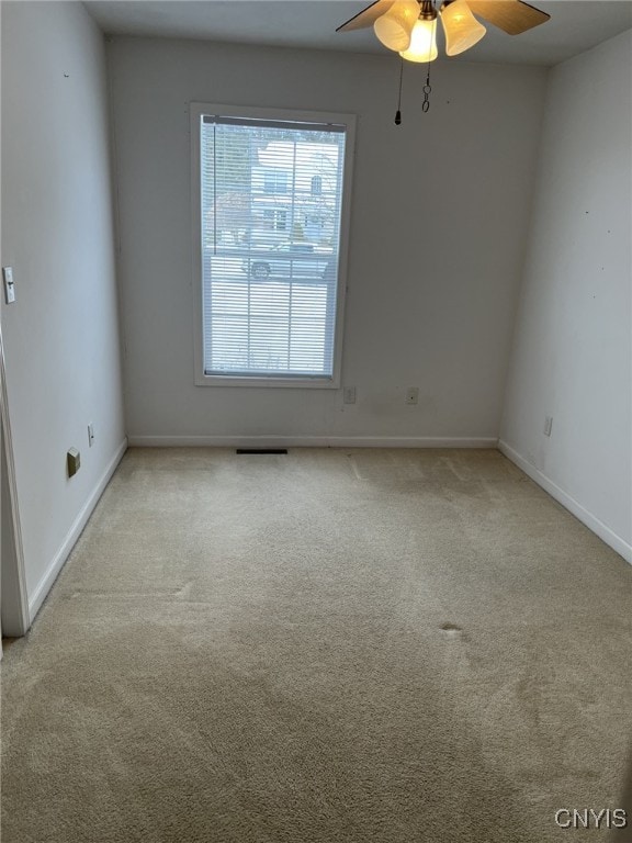 unfurnished room featuring ceiling fan and light carpet