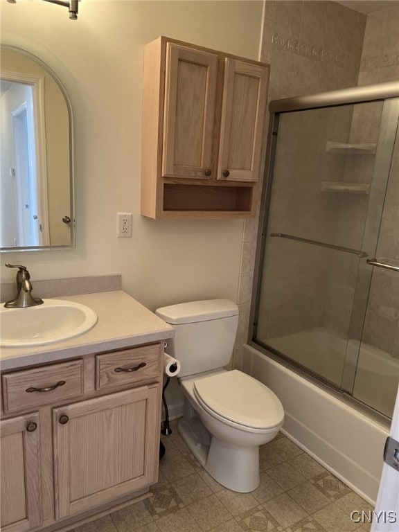 full bathroom featuring bath / shower combo with glass door, vanity, and toilet