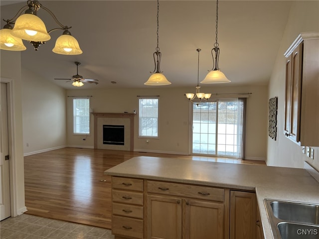 kitchen featuring lofted ceiling, sink, ceiling fan, and decorative light fixtures