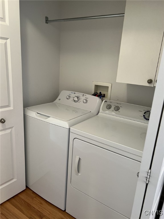 washroom with separate washer and dryer and hardwood / wood-style floors