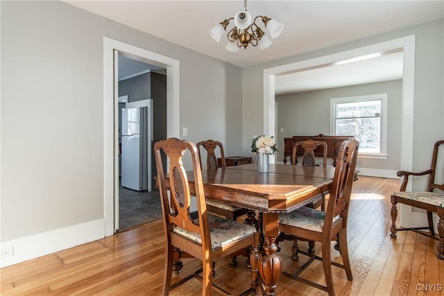 dining area featuring an inviting chandelier and light hardwood / wood-style flooring