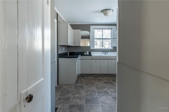 kitchen featuring white cabinetry and sink