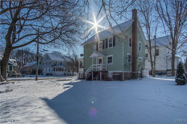 snow covered back of property with cooling unit