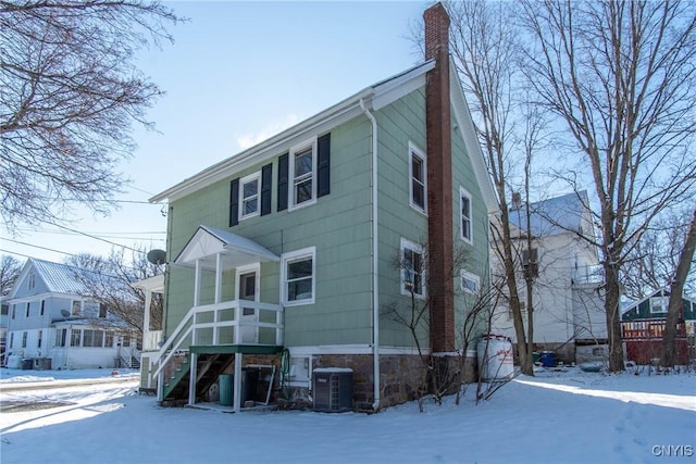 snow covered house with central AC