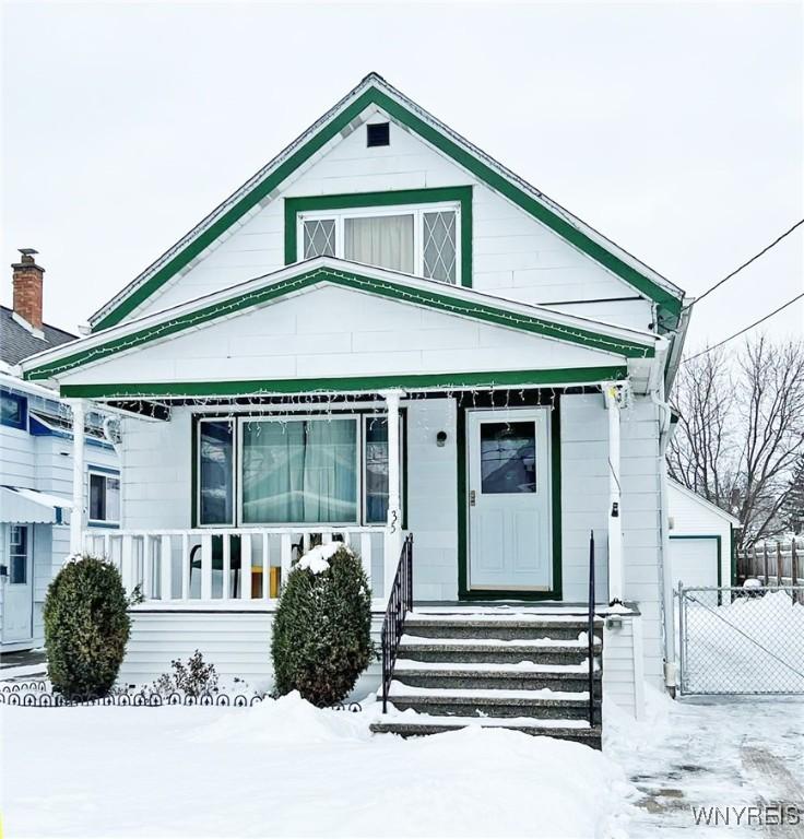 view of front of home with a garage, an outdoor structure, and a porch