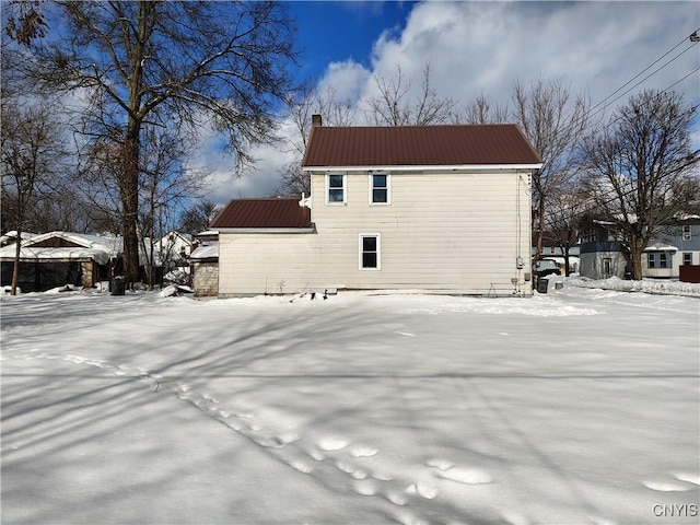 view of snow covered back of property